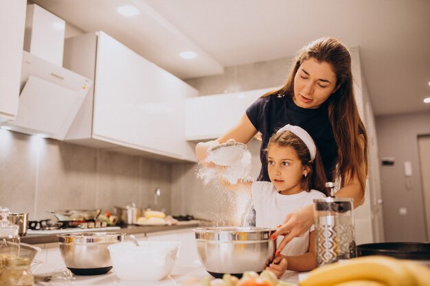 Madre con hija hornear juntos en la cocina