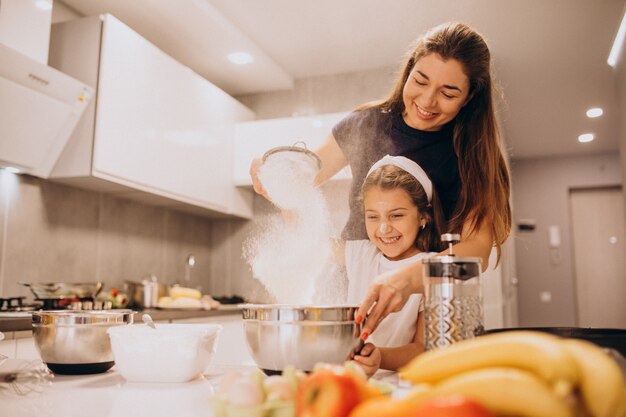 Madre con hija hornear juntos en la cocina