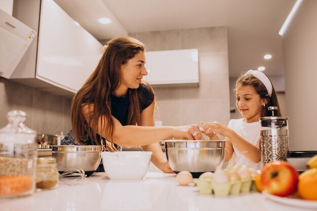 Madre con hija hornear juntos en la cocina