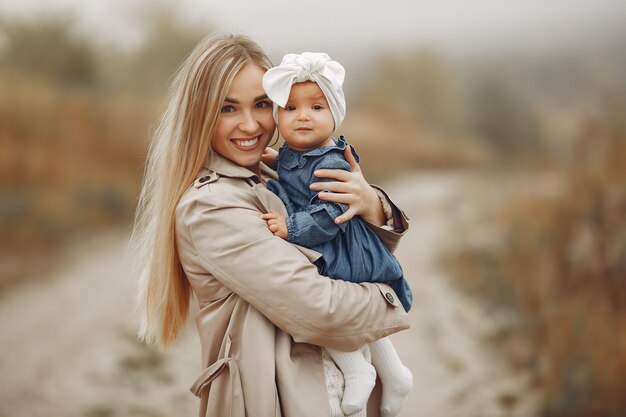 Madre con hija jugando en un campo de otoño