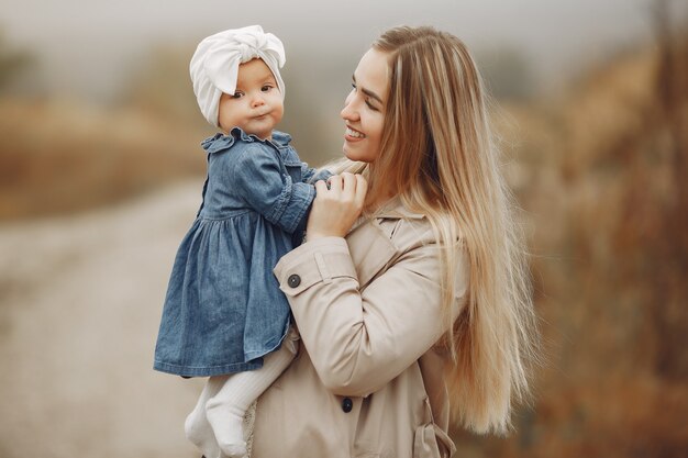 Madre con hija jugando en un campo de otoño