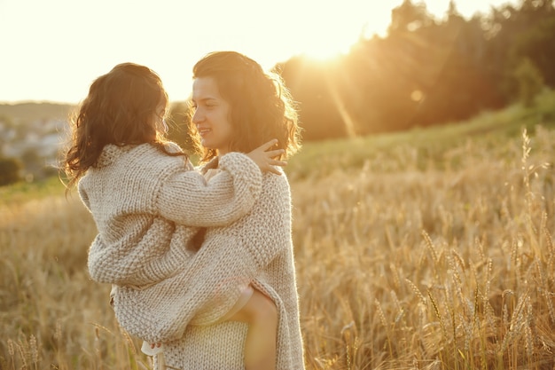 Madre con hija jugando en un campo de verano