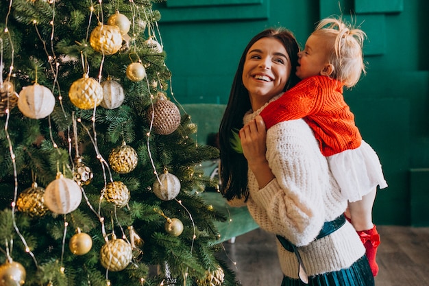 Madre con hija junto al árbol de navidad