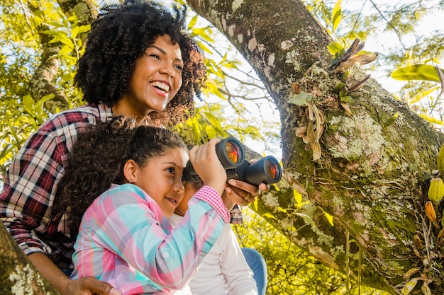 Madre con hija a lado de un árbol