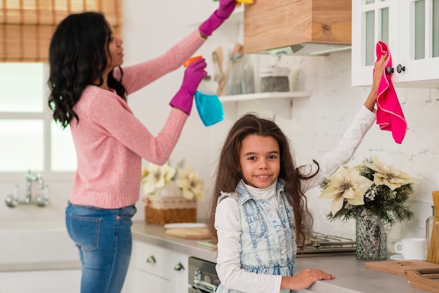 Madre con hija limpiando la casa