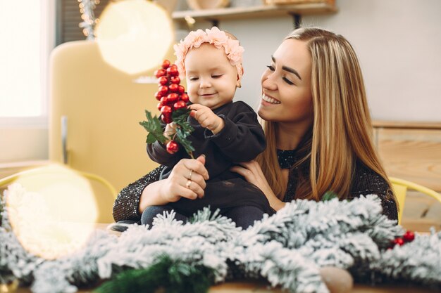 Madre con hija linda en una decoración navideña