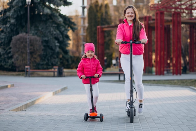 Madre con hija montando scooter eléctrico