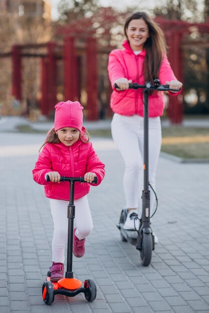 Madre con hija montando scooter eléctrico