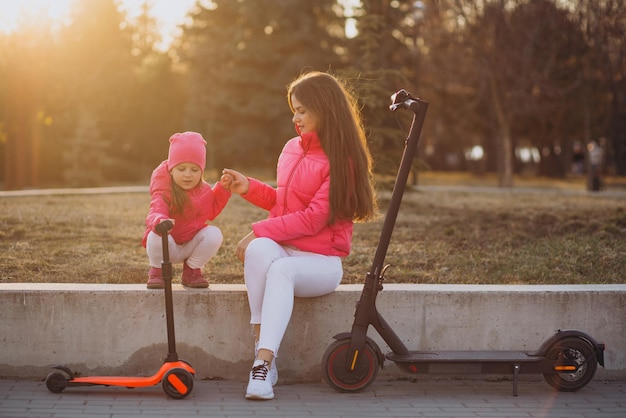 Foto gratuita madre con hija montando scooter eléctrico