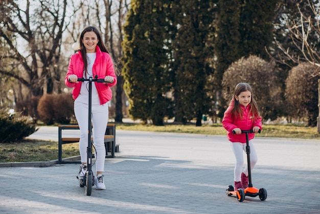 Madre con hija montando scooter eléctrico