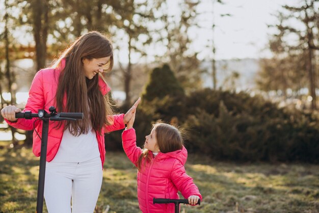 Madre con hija montando scooter eléctrico