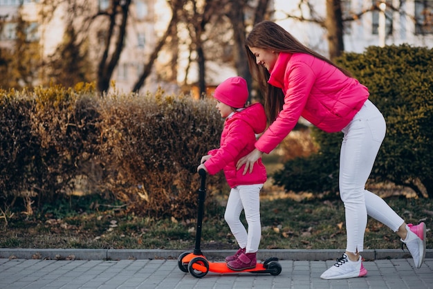 Madre con hija montando scooter eléctrico