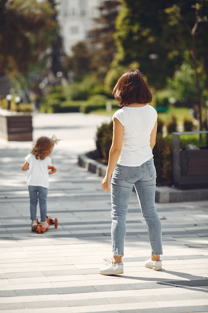 Madre con hija en un parque de primavera con skate