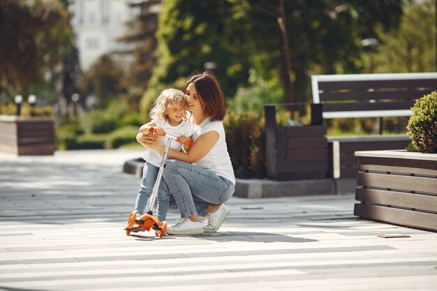 Madre con hija en un parque de primavera con skate