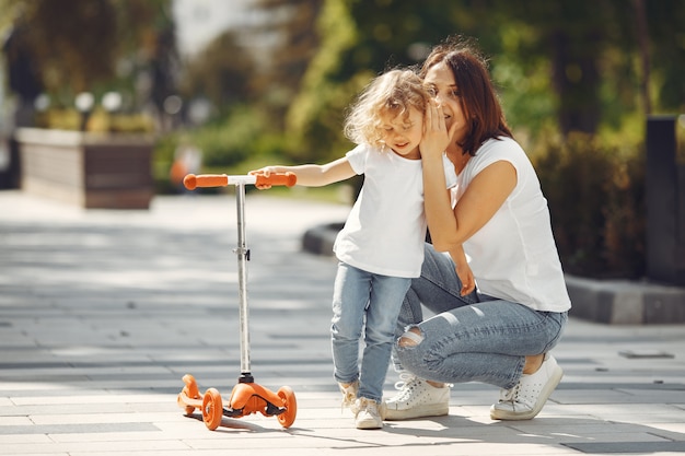 Madre con hija en un parque de primavera con skate