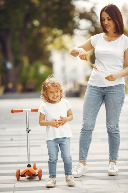 Madre con hija en un parque de primavera con skate