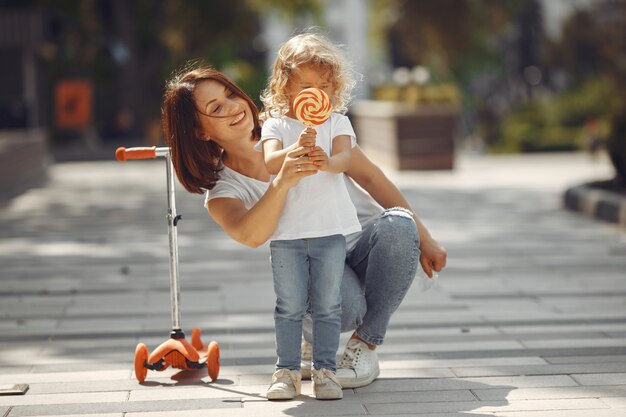 Madre con hija en un parque de primavera con skate