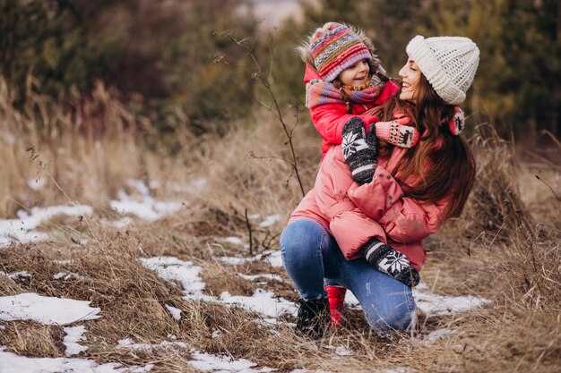 Madre con hija pequeña en un bosque de invierno