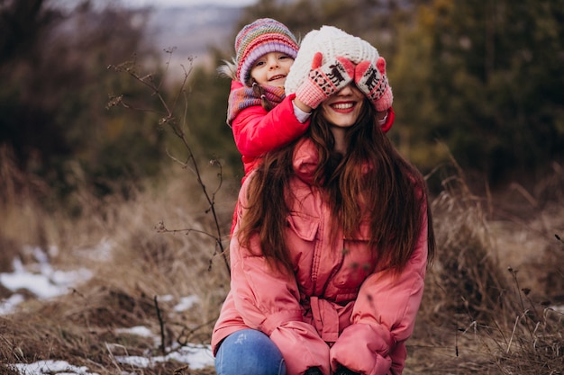 Madre con hija pequeña en un bosque de invierno