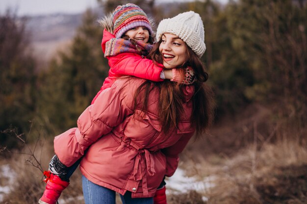 Madre con hija pequeña en un bosque de invierno