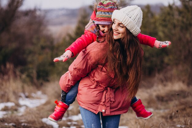 Madre con hija pequeña en un bosque de invierno