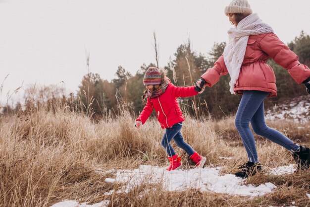 Madre con hija pequeña en un bosque de invierno