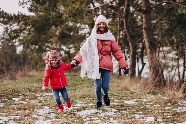 Madre con hija pequeña en un bosque de invierno