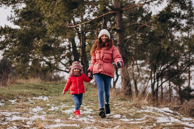 Madre con hija pequeña en un bosque de invierno