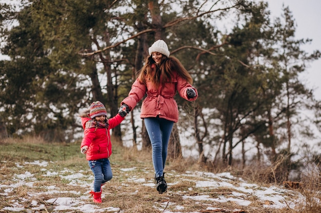 Madre con hija pequeña en un bosque de invierno