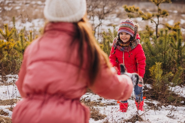 Madre con hija pequeña en un bosque de invierno