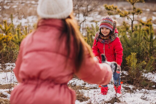 Madre con hija pequeña en un bosque de invierno