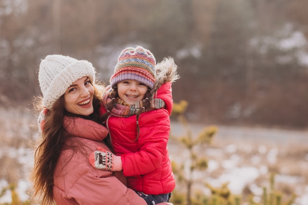 Madre con hija pequeña en un bosque de invierno