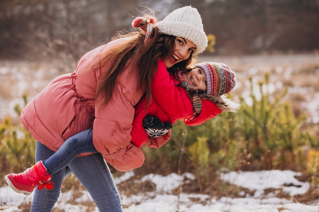 Madre con hija pequeña en un bosque de invierno