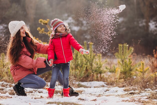 Madre con hija pequeña en un bosque de invierno