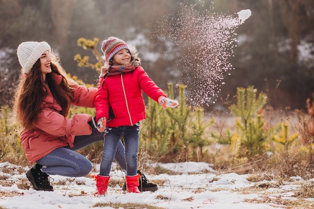 Madre con hija pequeña en un bosque de invierno