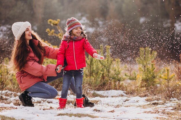 Madre con hija pequeña en un bosque de invierno