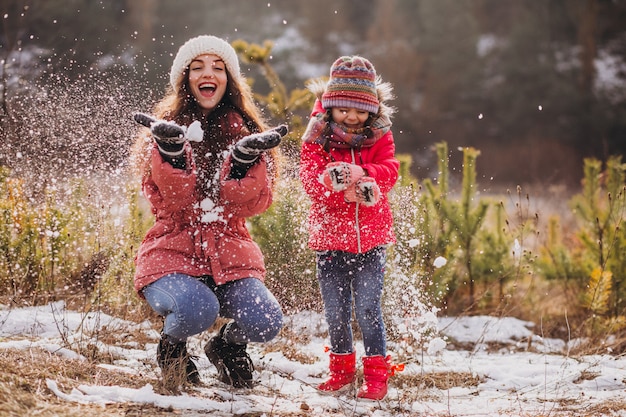 Madre con hija pequeña en un bosque de invierno