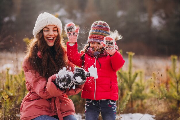 Madre con hija pequeña en un bosque de invierno