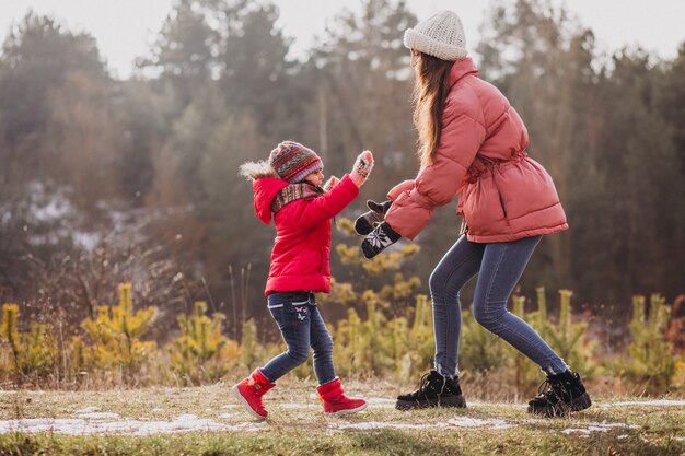 Madre con hija pequeña en un bosque de invierno