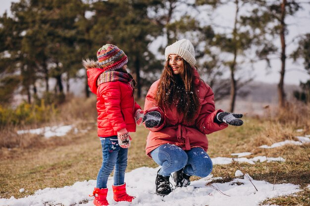 Madre con hija pequeña en un bosque de invierno