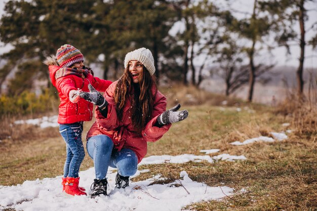 Madre con hija pequeña en un bosque de invierno