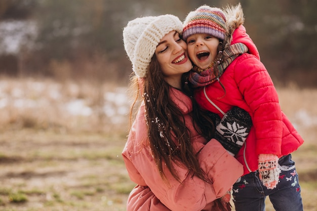 Madre con hija pequeña en un bosque de invierno