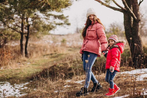 Madre con hija pequeña en un bosque de invierno