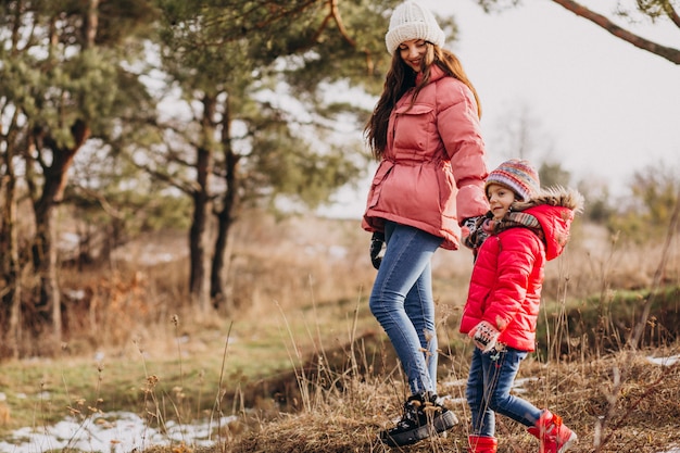 Madre con hija pequeña en un bosque de invierno