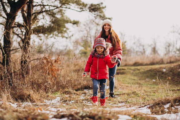 Madre con hija pequeña en un bosque de invierno