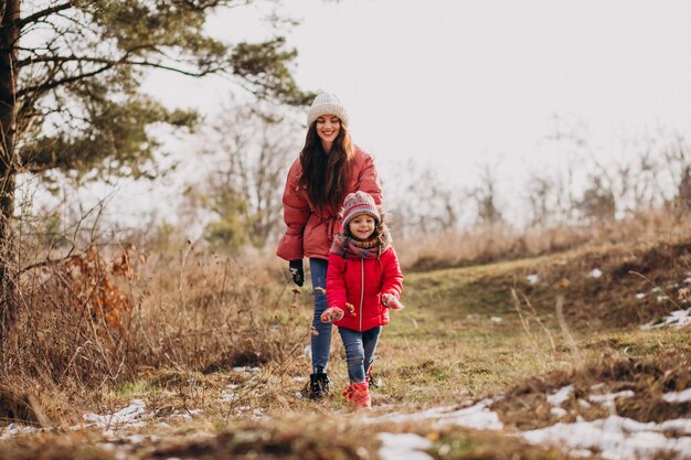 Madre con hija pequeña en un bosque de invierno