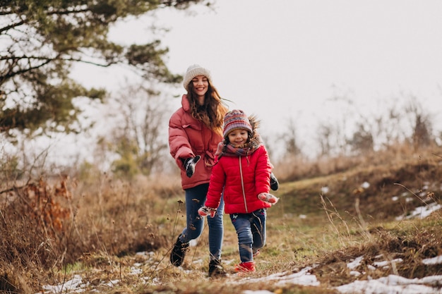 Madre con hija pequeña en un bosque de invierno