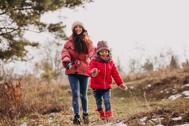 Madre con hija pequeña en un bosque de invierno