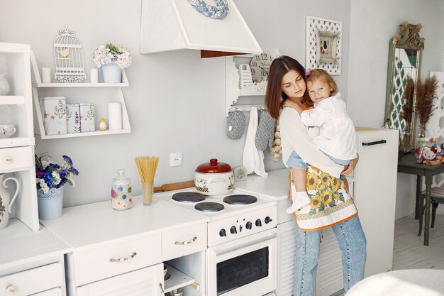 Madre con hija pequeña cocinando en casa