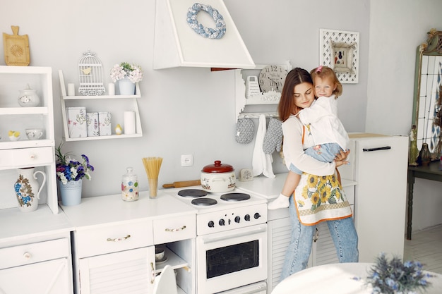 Madre con hija pequeña cocinando en casa